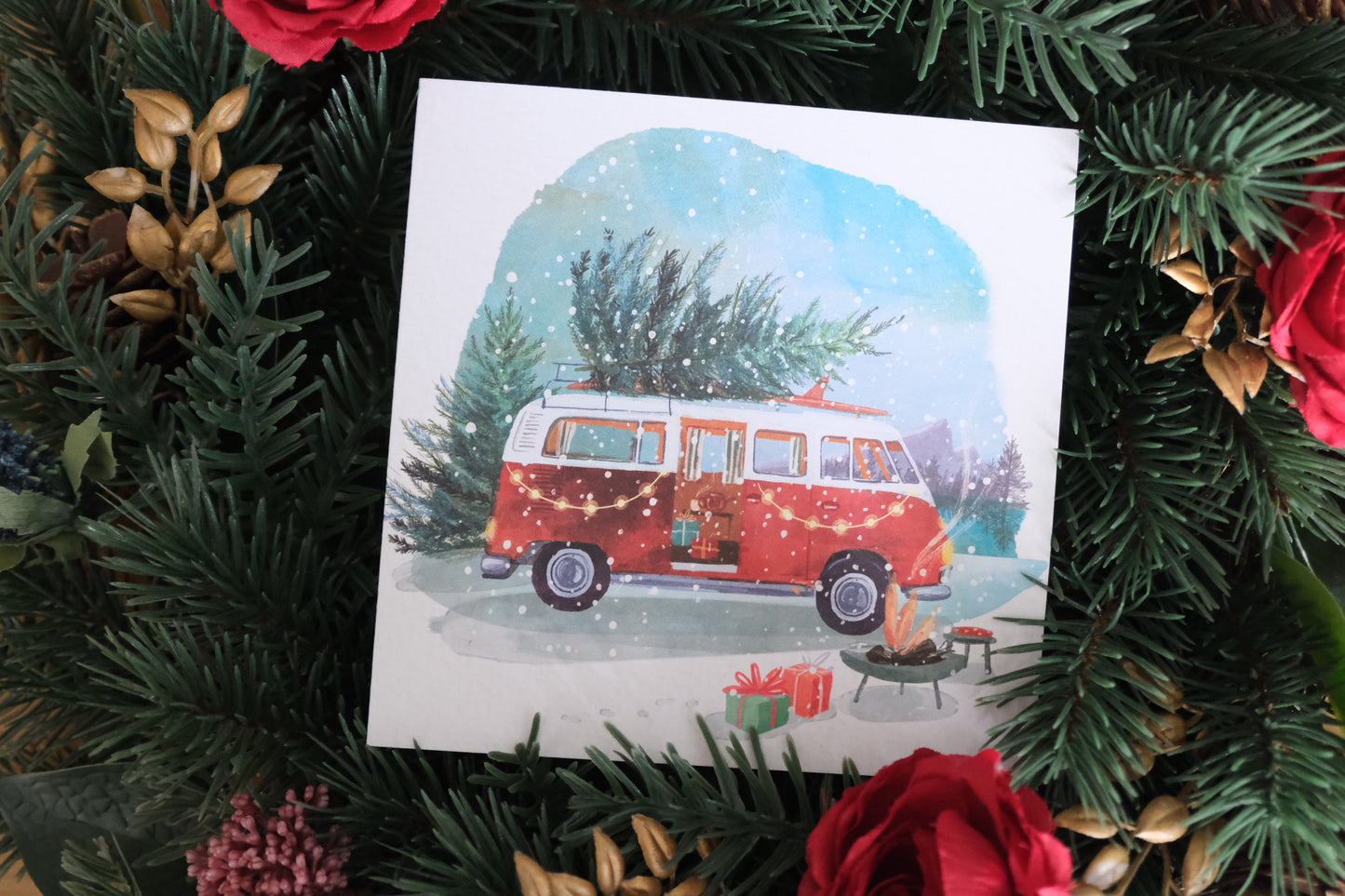 Christmas card depecting a classic camper van with a Christmas tree on the roof.