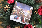 Christmas card depicting the village of Haworth, surrounded by festive greenery and red flowers.